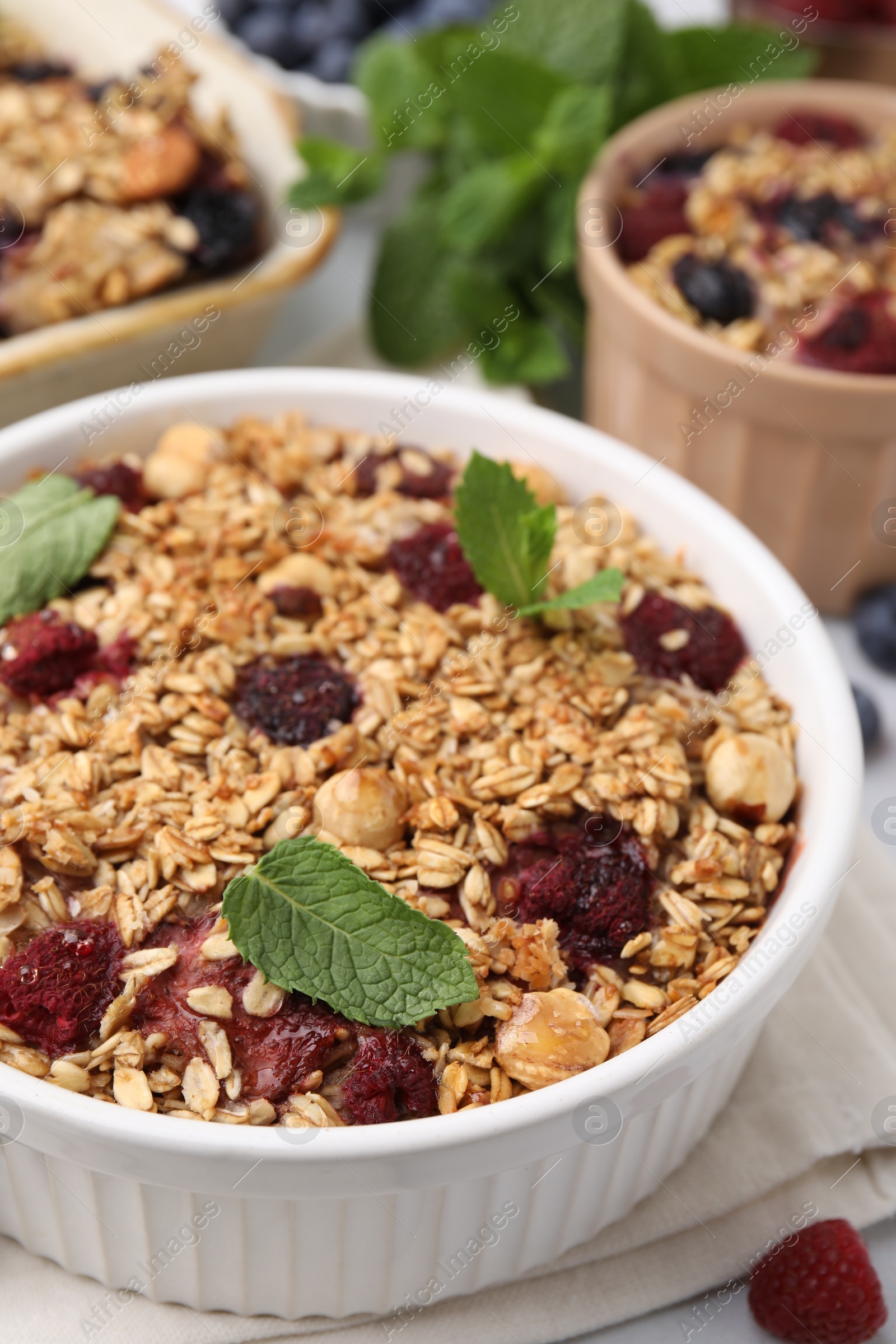 Photo of Tasty baked oatmeal with berries and nuts on table, closeup