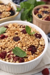 Tasty baked oatmeal with berries and nuts on table, closeup