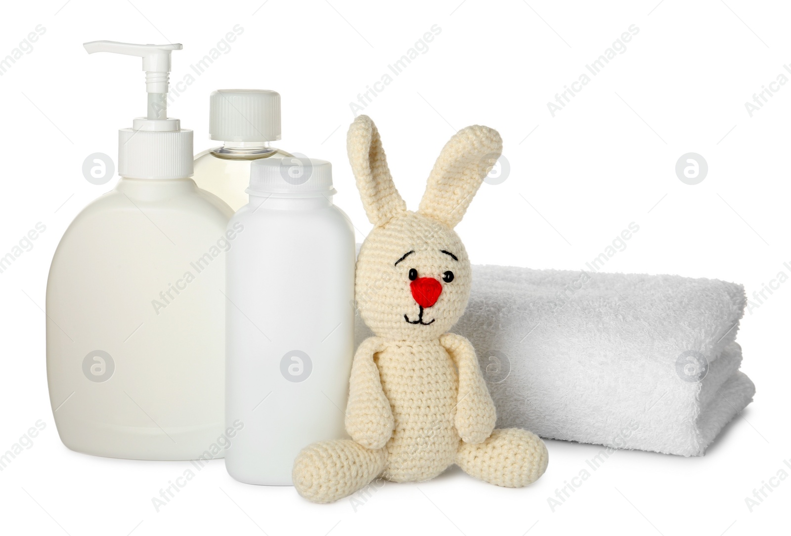 Photo of Bottles of baby cosmetic products, towel and bunny toy on white background