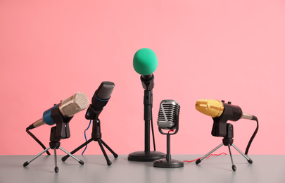 Photo of Microphones on table against pink background. Journalist's work