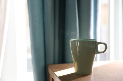 Photo of Delicious morning coffee on wooden table indoors. Space for text