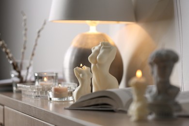 Photo of Beautiful body shaped candles on table indoors
