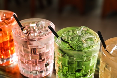 Photo of Glasses of delicious cocktails with ice on table, closeup