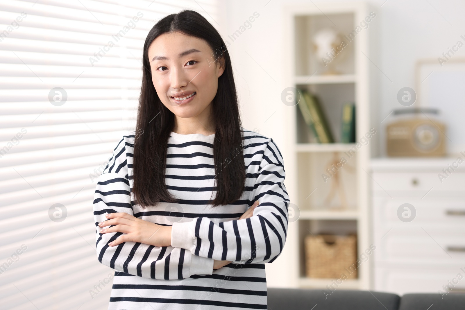 Photo of Portrait of smiling businesswoman with crossed arms in office