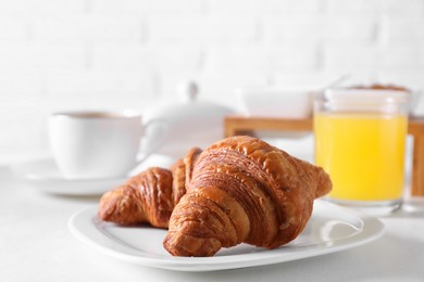 Photo of Fresh croissants on white table. Tasty breakfast