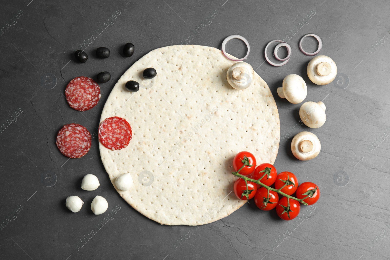 Photo of Flat lay composition with base and ingredients for pizza on grey table