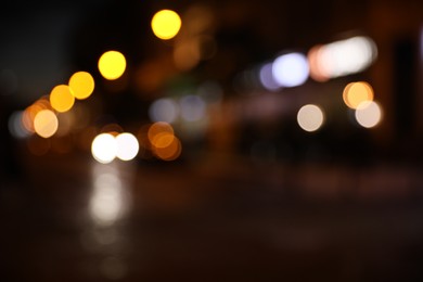 Photo of Blurred view of city street with lights at night. Bokeh effect