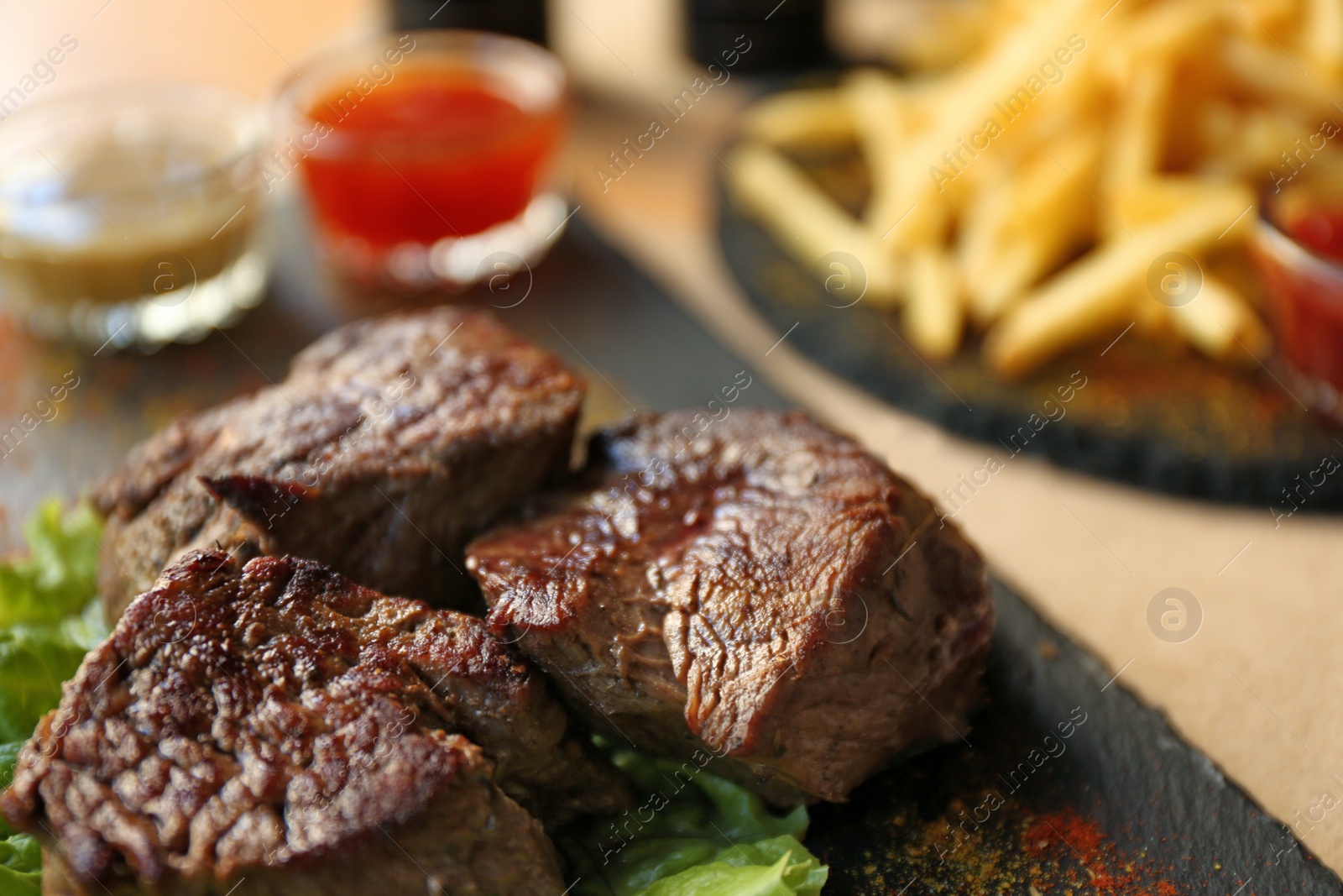 Photo of Tasty pieces of shish kebab served on slate plate in cafe