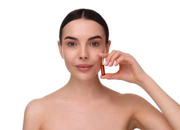 Beautiful young woman holding skincare ampoule on white background