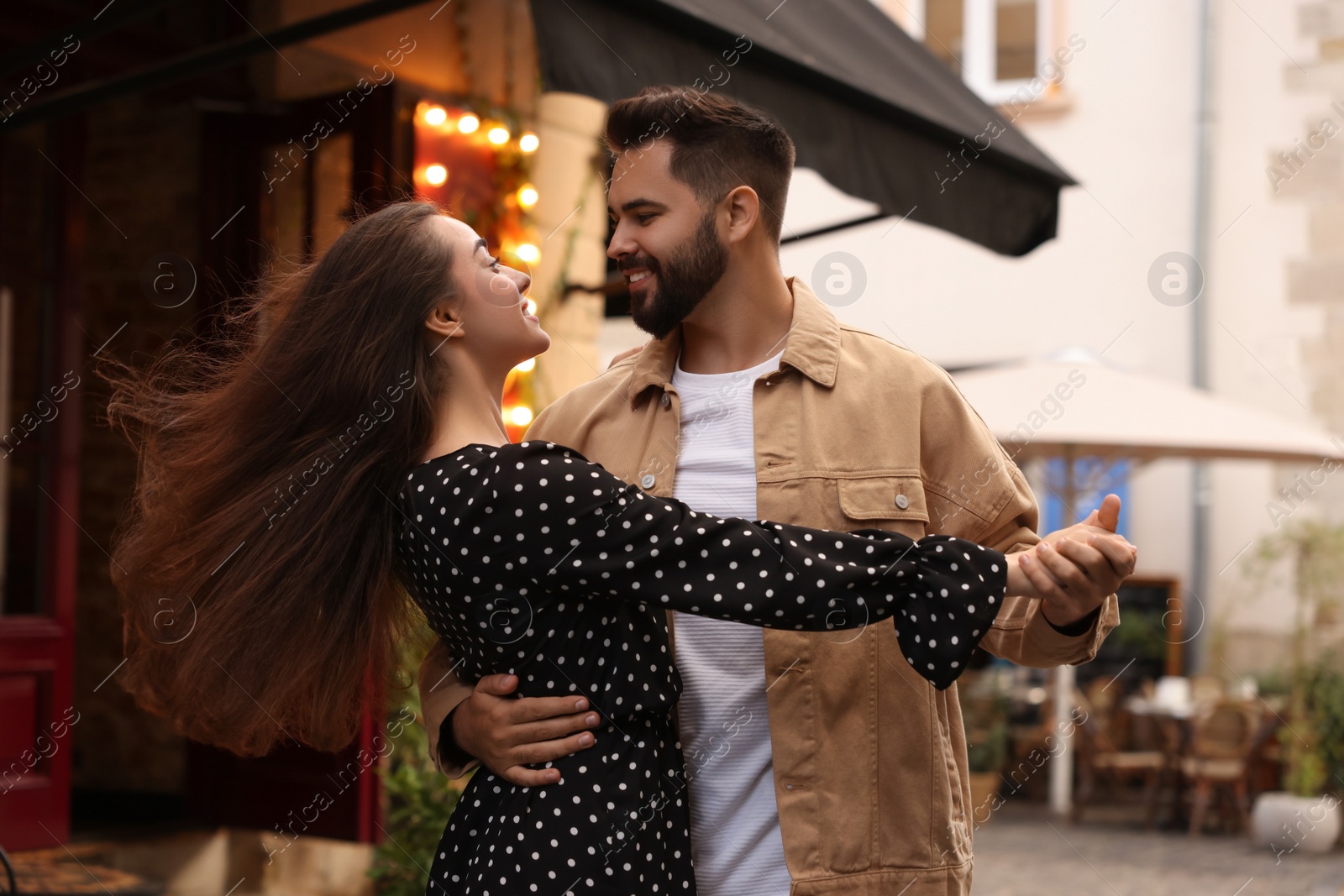 Photo of Lovely couple dancing together on city street