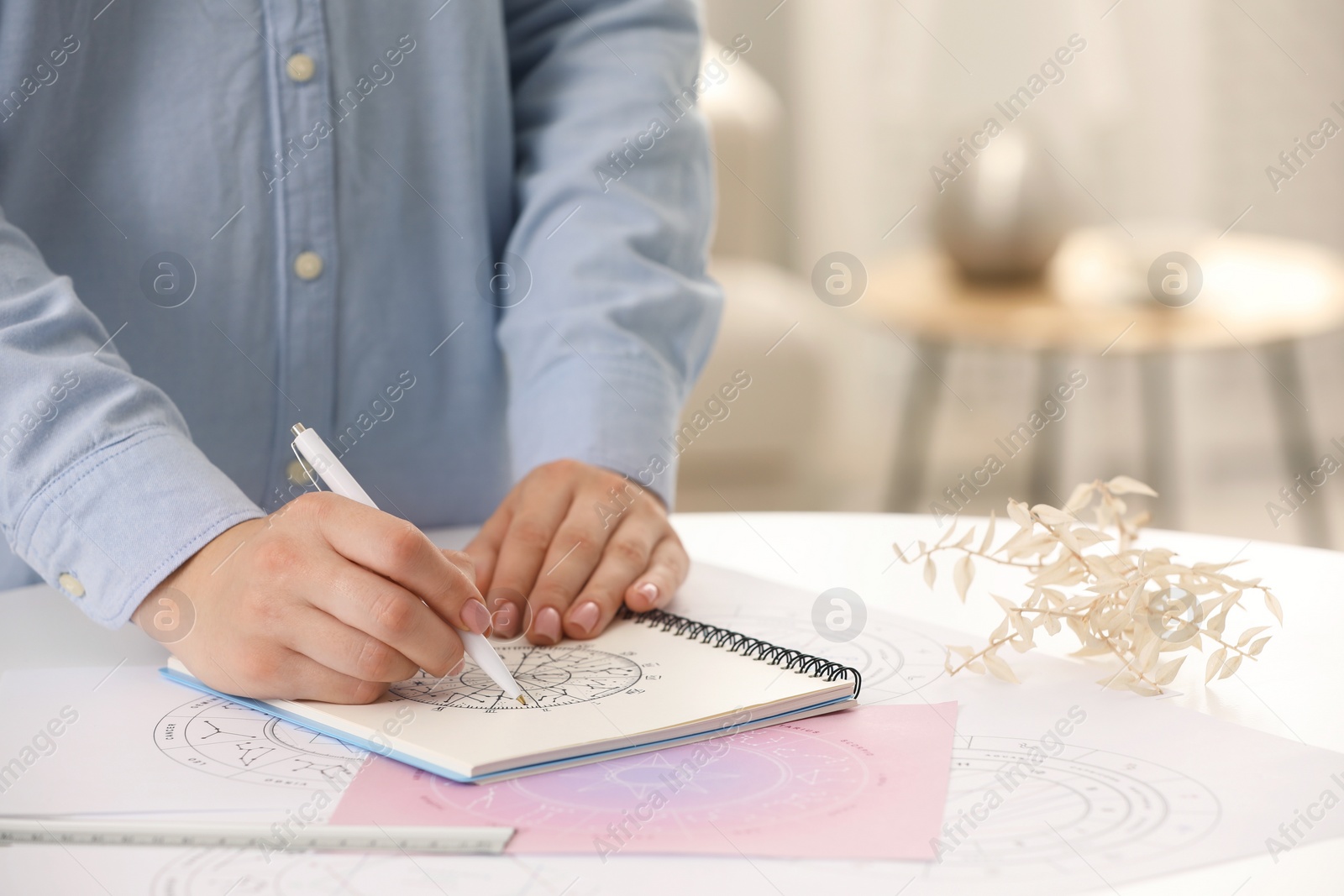 Photo of Astrologer using zodiac wheel for fate forecast at table, closeup and space for text. Fortune telling