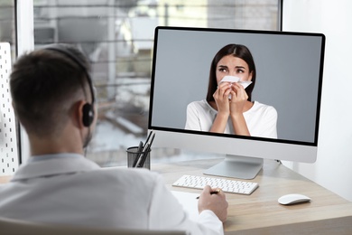 Hotline service. Doctor consulting patient online via computer indoors