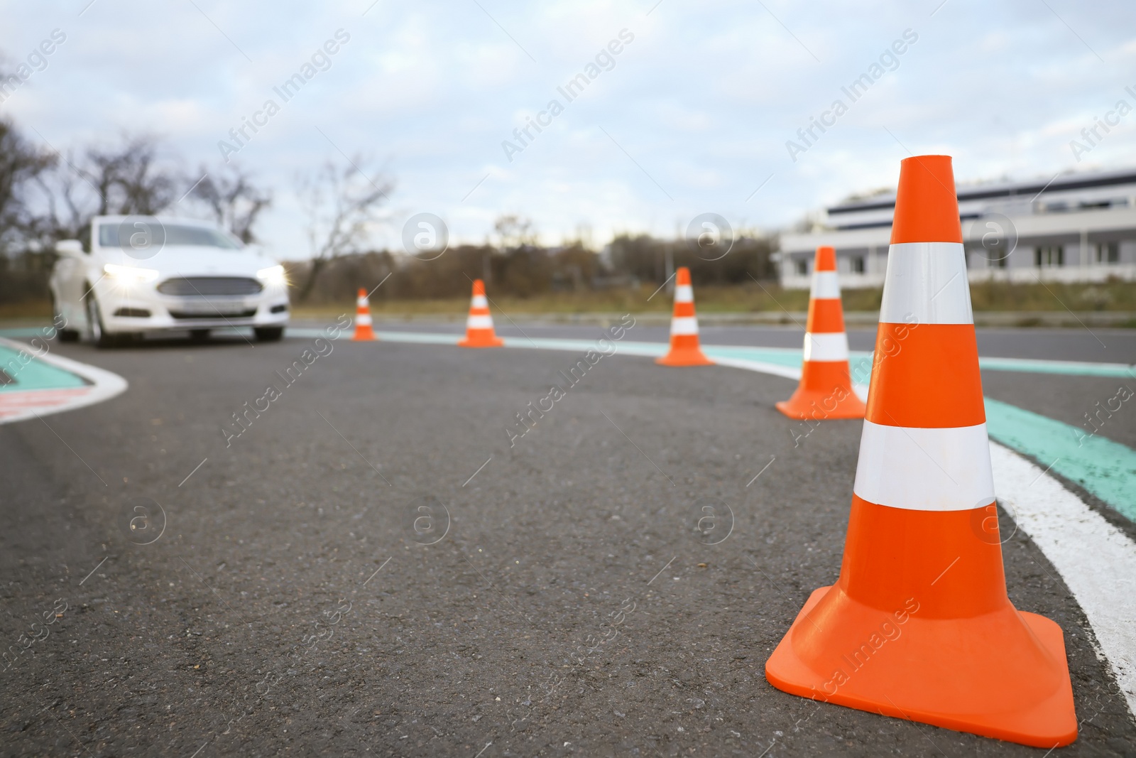 Photo of Modern car at test track, focus on traffic cone. Driving school