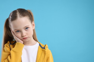 Photo of Portrait of sad girl on light blue background, space for text