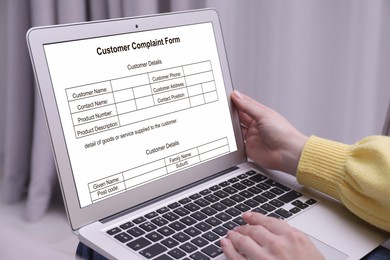 Image of Woman filling online complaint form via laptop indoors, closeup