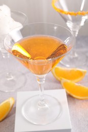 Tasty cocktails in glasses and orange slices on gray table, closeup
