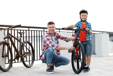 Photo of Dad and son with bicycle near river