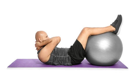 Photo of Overweight man doing exercise with fitness ball on white background