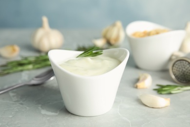 Photo of Composition with bowl of garlic sauce on grey table