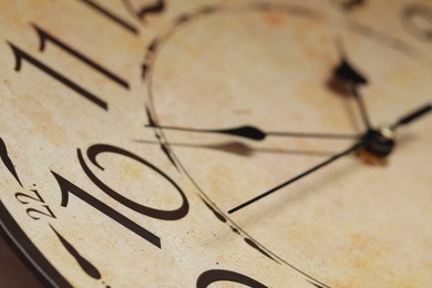 Photo of Closeup view of stylish beige clock. Interior element