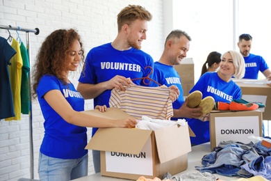 Photo of Team of volunteers collecting donations in boxes indoors