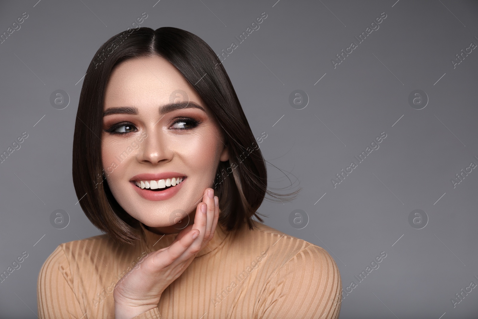 Image of Portrait of pretty young woman with brown hair smiling on grey background, space for text