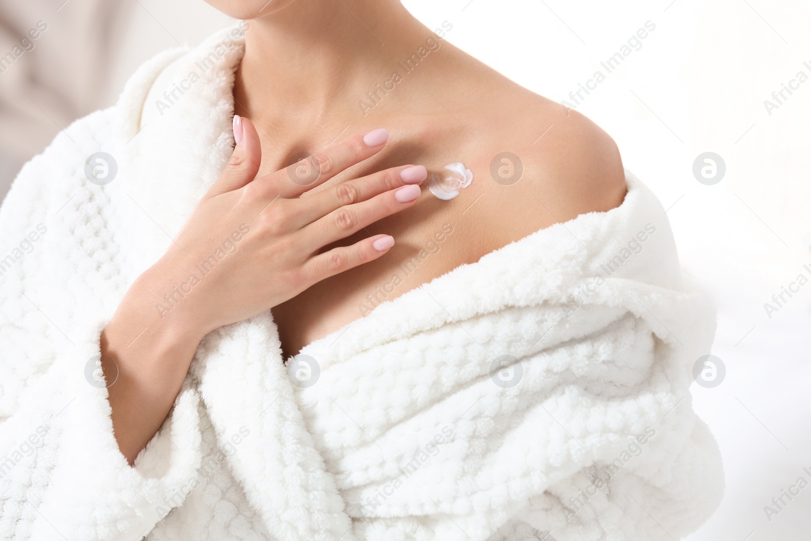 Photo of Young woman applying cream indoors, closeup. Beauty and body care