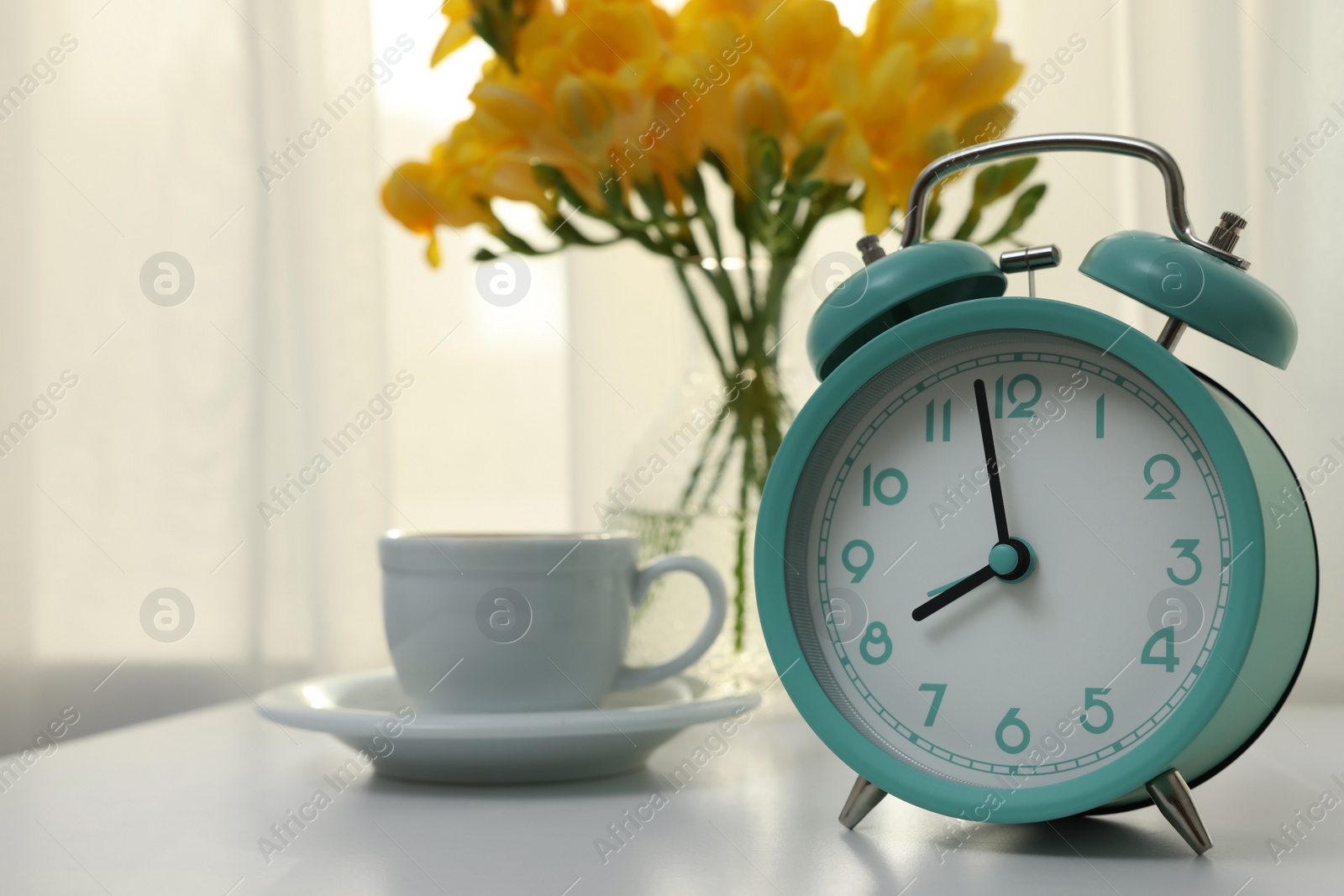 Photo of Alarm clock on white table indoors, space for text. Morning time
