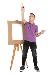 Child painting picture on easel against white background. Space for text