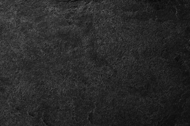 Texture of dark grey stone surface as background, closeup