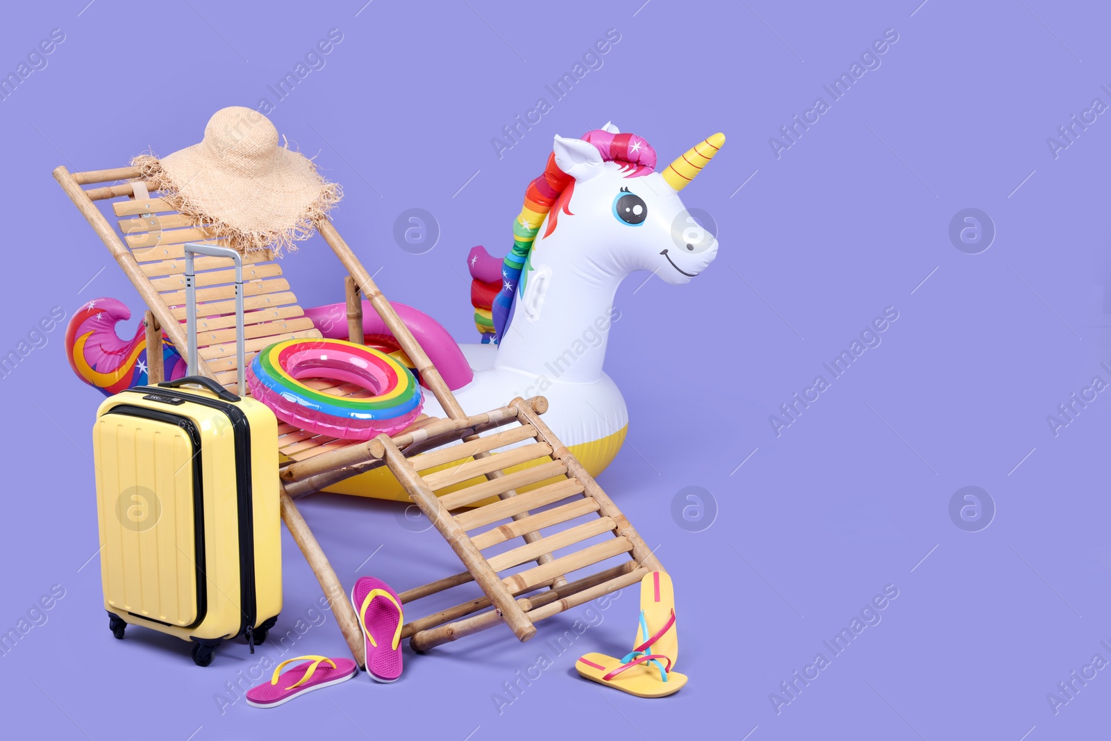 Photo of Deck chair, suitcase and beach accessories on purple background, space for text. Summer vacation