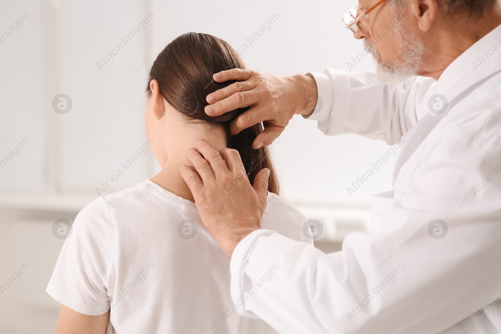 Photo of Professional orthopedist examining patient's neck in clinic, closeup