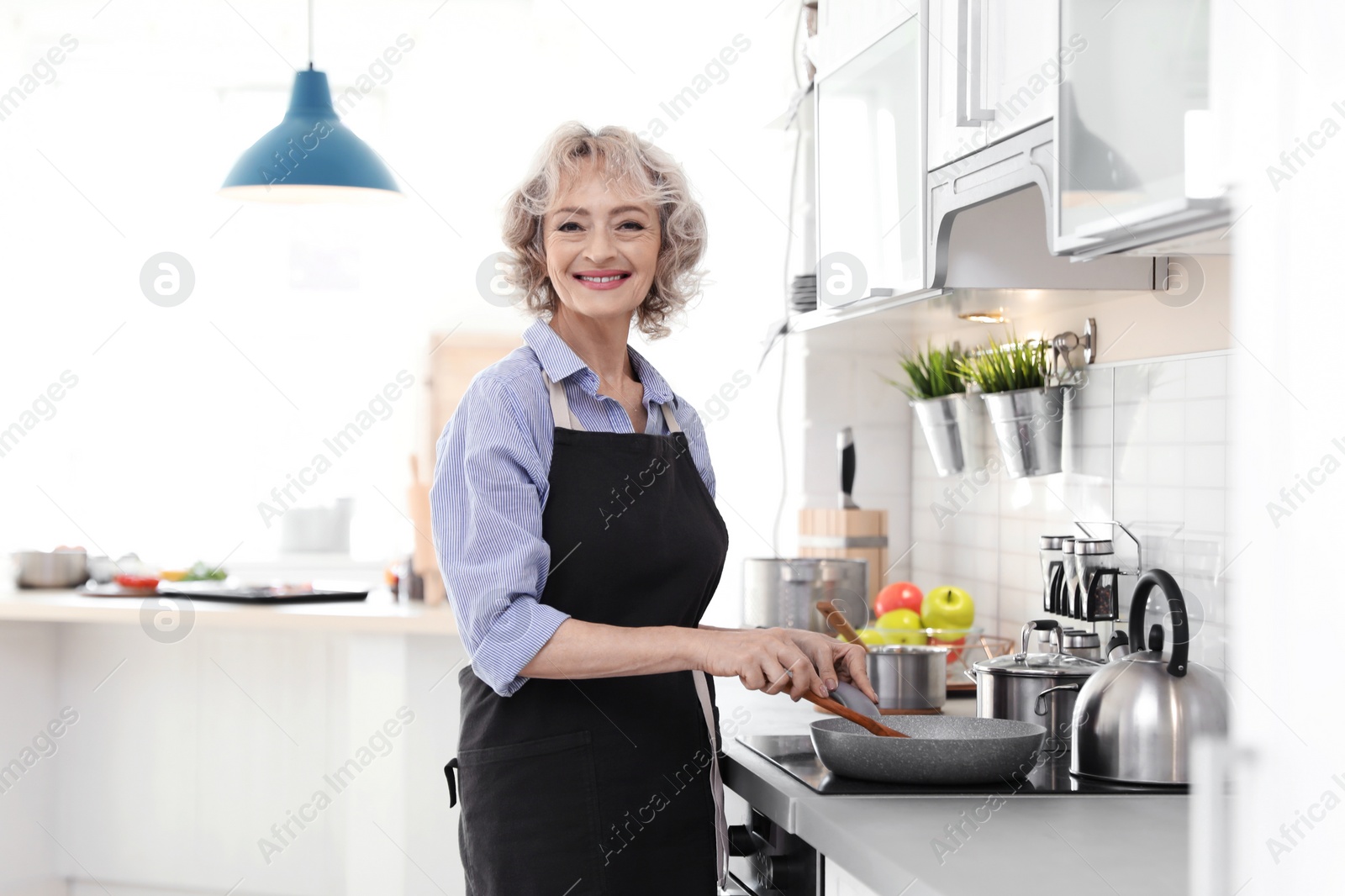 Photo of Professional female chef cooking vegetables in kitchen