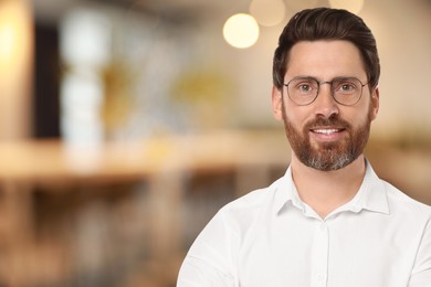 Image of Handsome confident man with eyeglasses in office, space for text