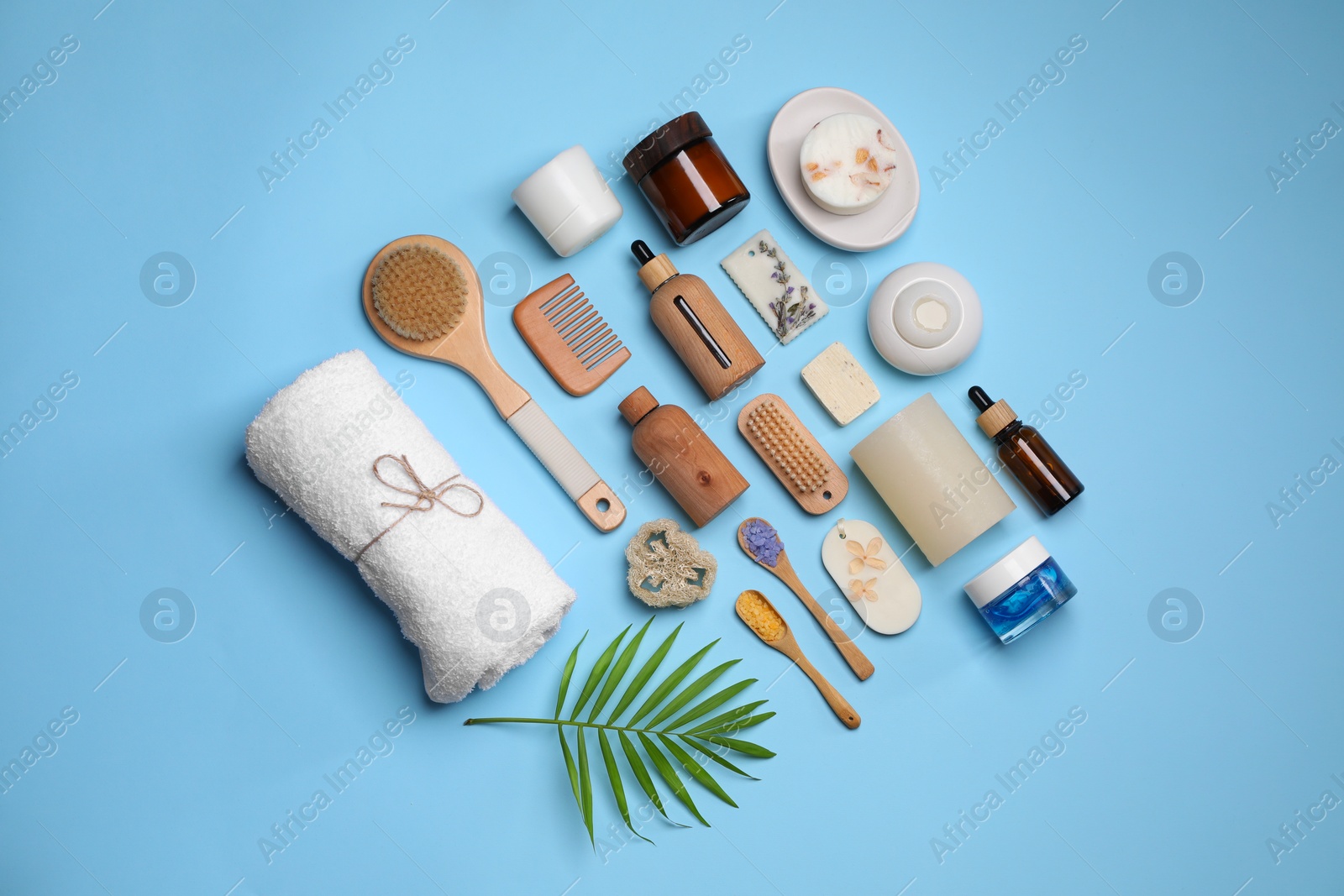 Photo of Flat lay composition with different spa products and tropical leaf on light blue background