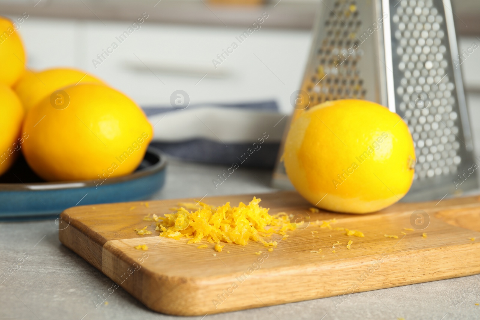 Photo of Lemon zest and fresh fruits on grey table, closeup
