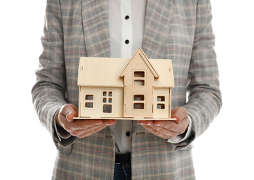 Photo of Real estate agent holding house model on white background, closeup