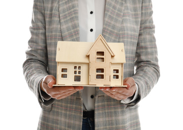 Real estate agent holding house model on white background, closeup