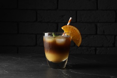 Tasty refreshing drink with coffee and orange juice on grey table against dark background