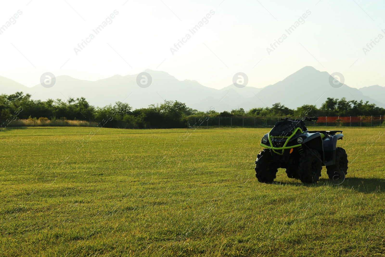 Photo of Modern quad bike in field on sunny day, space for text