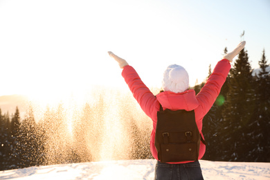 Young woman having fun outdoors on snowy winter day