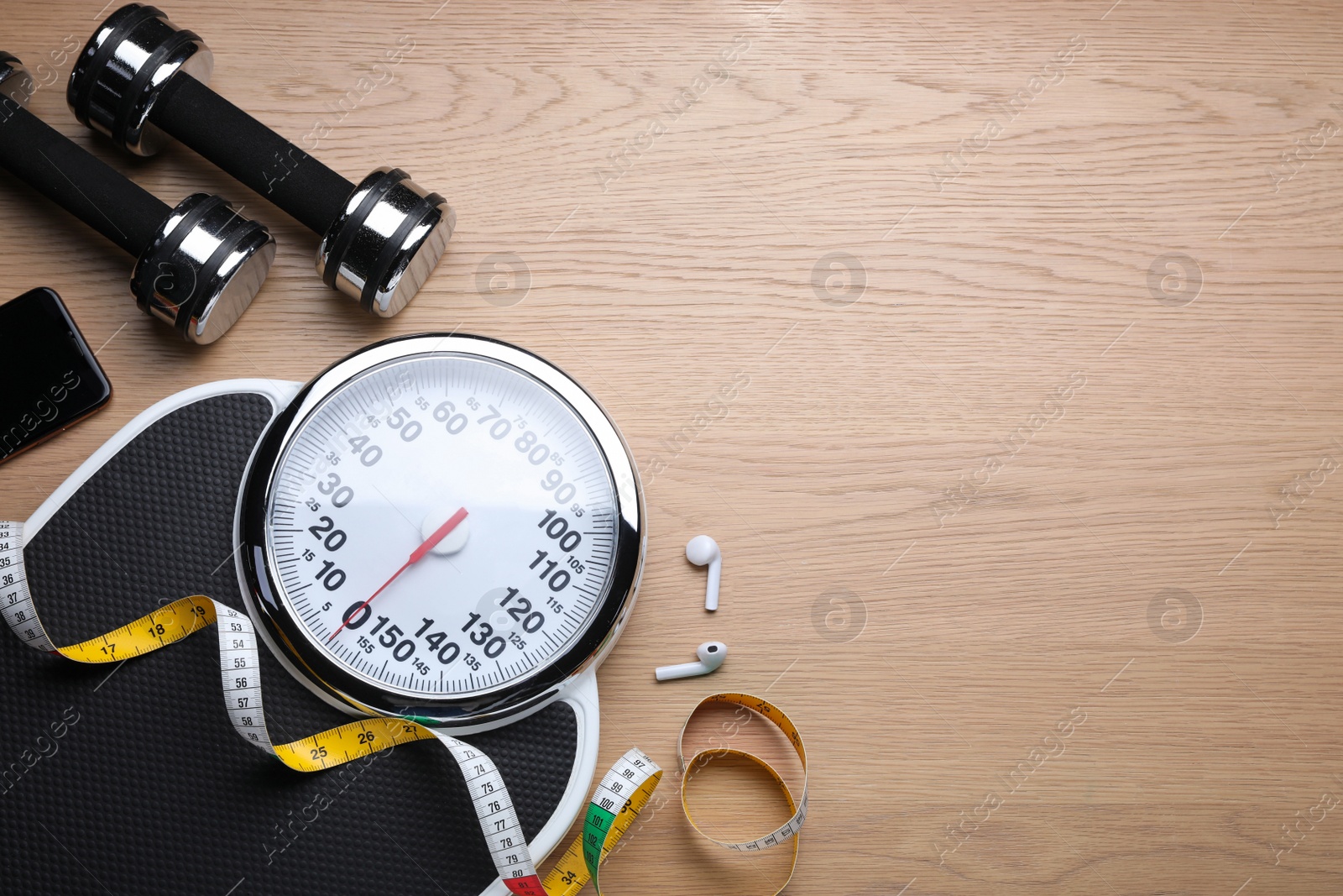 Photo of Flat lay composition with scales and measuring tape on wooden background, space for text