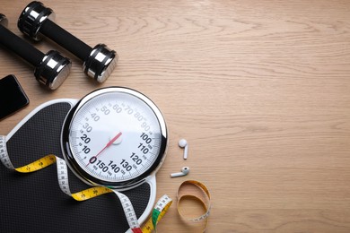 Flat lay composition with scales and measuring tape on wooden background, space for text