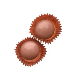 Delicious pink chocolate candies on white background, top view