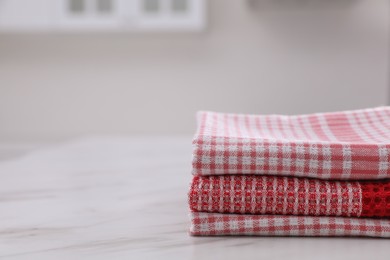 Photo of Stack of kitchen towels on white marble table. Space for text