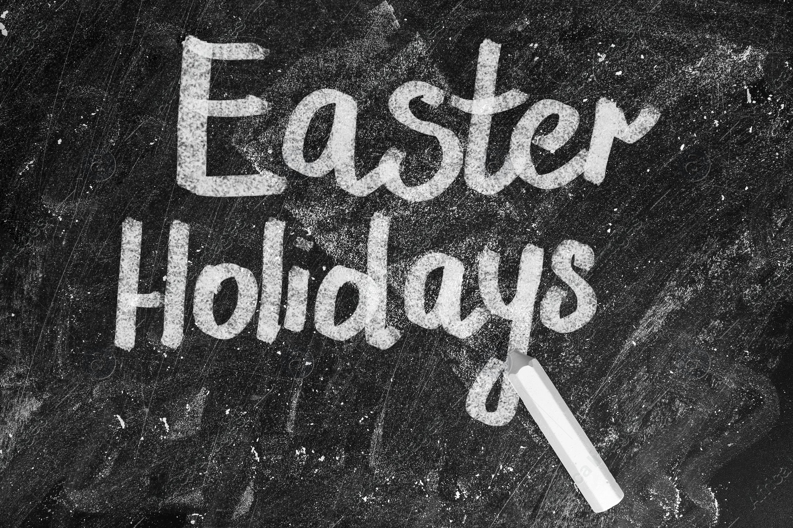 Image of Text Easter Holidays and chalk on blackboard, top view. School break 