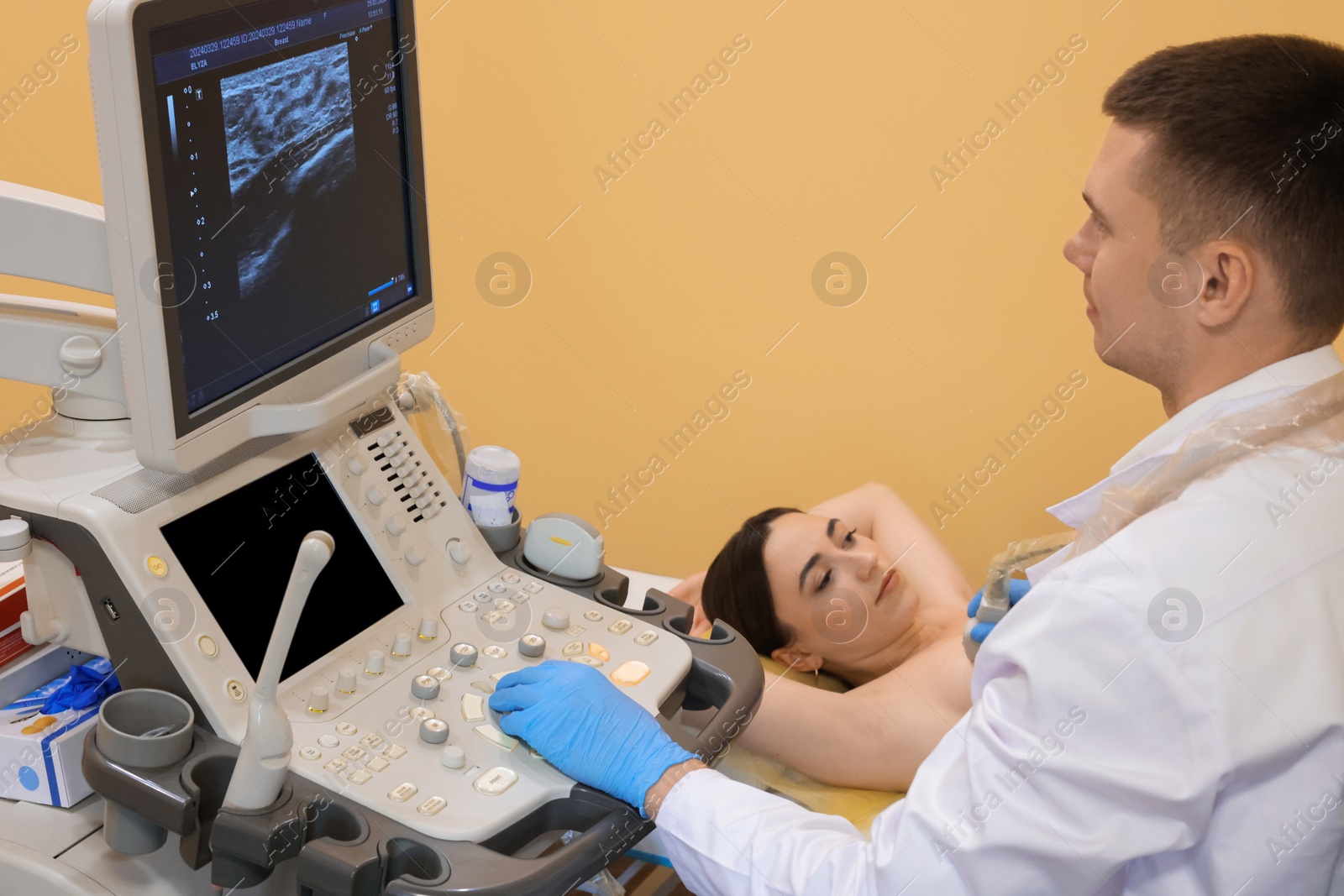 Photo of Mammologist conducting ultrasound examination of woman's breast in clinic