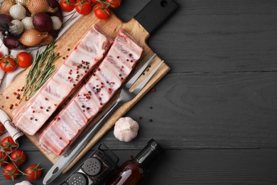 Photo of Flat lay composition with raw pork ribs and spices on grey wooden table. Space for text