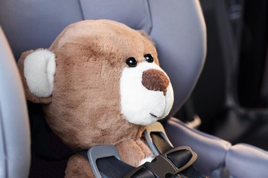 Photo of Teddy bear in child safety seat inside car