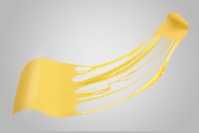 Image of Tasty cheese stretching in air on grey background